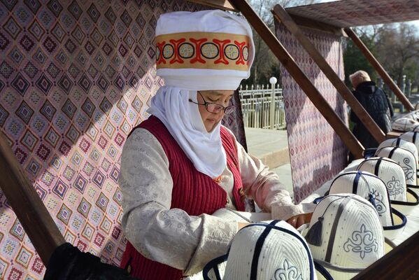 Женщина в национальной одежде продает головные уборы - Sputnik Кыргызстан