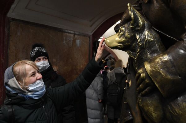 Пассажиры в защитных масках возле скульптуры на станции &quot;Площадь Революции&quot; Московского метрополитена - Sputnik Кыргызстан