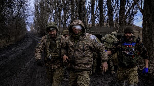 Украинские боевые медики эвакуируют раненого украинского военнослужащего с линии фронта под Бахмутом - Sputnik Кыргызстан
