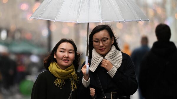 Девушки с зонтиком во время дождя. Архивное фото - Sputnik Кыргызстан