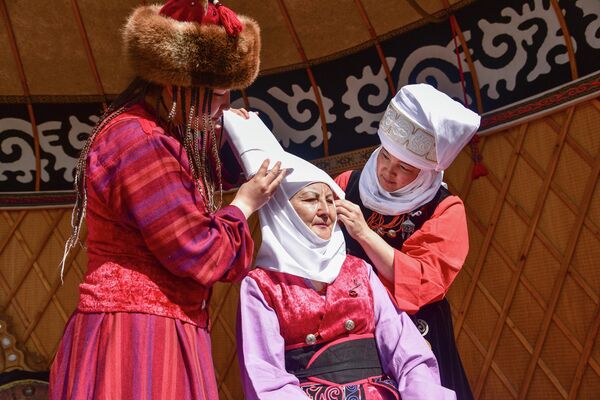 Женщине помогают надеть элечек — кыргызский женский головной убор - Sputnik Кыргызстан