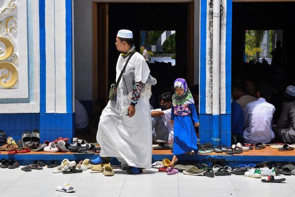 Мужчина с дочерью у мечети во время молитвы на второй день священного для мусульман месяца Рамадан в городе Тагиге в пригороде Манилы (Индонезия) - Sputnik Кыргызстан