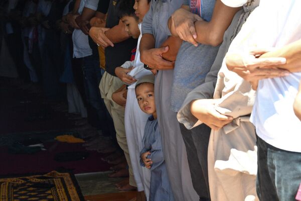 Ребенок молится вместе с родственниками в мечети в городе Тагиге в пригороде Манилы (Индонезия) - Sputnik Кыргызстан