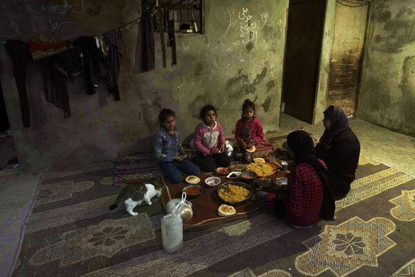 Мусульманская семья разговляется в первый день священного месяца Рамадан в доме рядом с трущобами на окраине Хан-Юниса (южная часть сектора Газа) - Sputnik Кыргызстан
