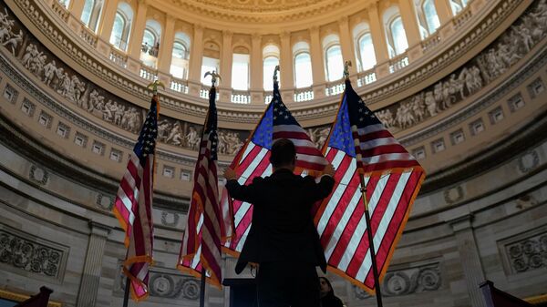 Вашингтондогу Капитолий имаратында киши АКШнын желектерин тууралап жатат. Архив - Sputnik Кыргызстан
