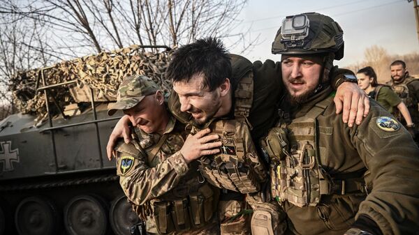 Раненого украинского военнослужащего уносят с поля боя недалеко от Артемовска - Sputnik Кыргызстан