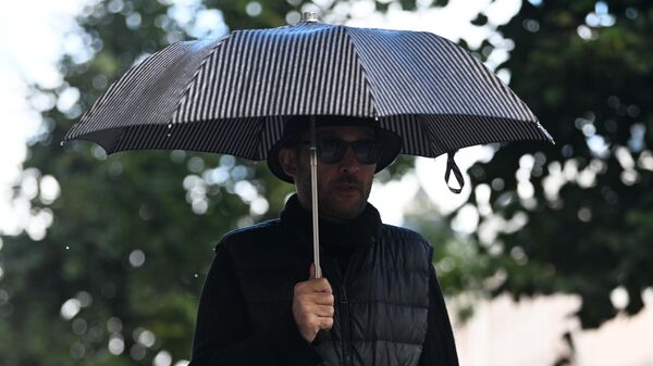 Мужчина с зонтом во время дождя. Архивное фото - Sputnik Кыргызстан