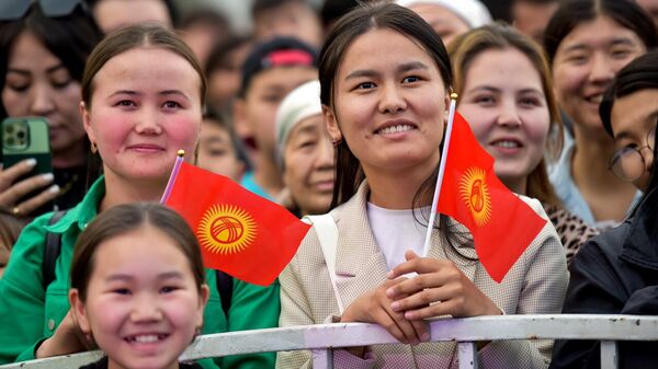 Бишкекте концерт учурунда КР желегктерин кармап турган кыздар. Архив - Sputnik Кыргызстан