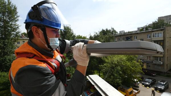 Муниципальный рабочий производит ремонт фонаря уличного освещения. Архивное фото - Sputnik Кыргызстан