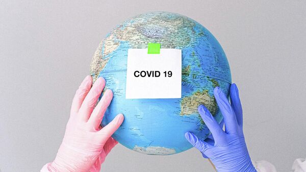 Люди в перчатках держат глобус с заметкой Covid-19. Иллюстративное фото - Sputnik Кыргызстан