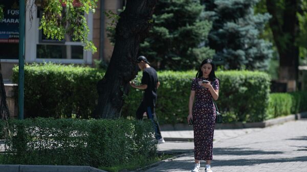 Девушка со смартфоном переходи дорогу в Бишкеке - Sputnik Кыргызстан