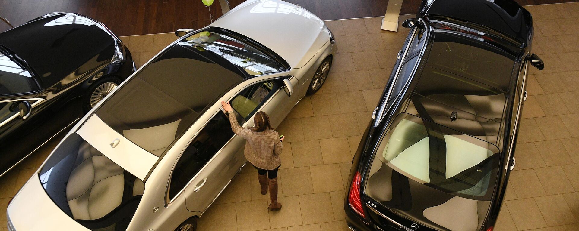 Менеджер демонстрирует покупателям автомобиль в автосалоне. Архивное фото - Sputnik Кыргызстан, 1920, 02.06.2023