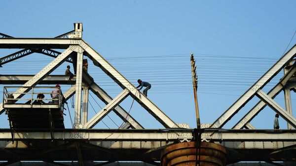 Индийские рабочие ремонтируют железнодорожный мост через реку Ганг - Sputnik Кыргызстан
