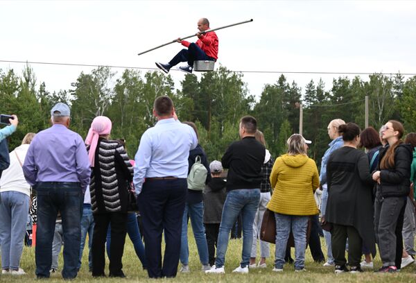 Люди наблюдают за канатоходцем на ежегодном празднике &quot;Сабантуй&quot; в день окончания весенних полевых работ в Лаишевском районе Татарстана - Sputnik Кыргызстан