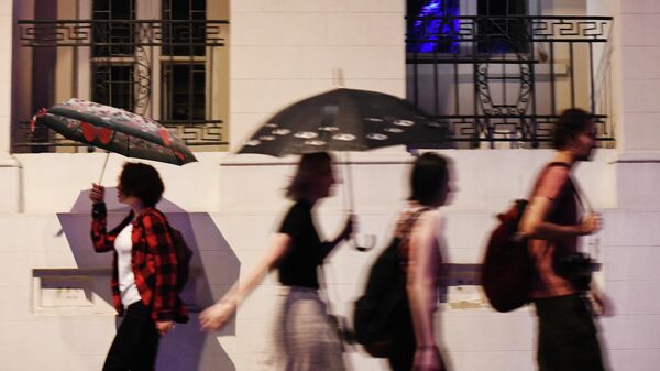 Девушки с зонтами идут по улице. Архивное фото - Sputnik Кыргызстан