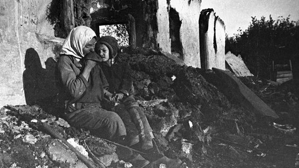 Работница колхоза им. Ильича с ребенком у развалин своего дома . Архивное фото - Sputnik Кыргызстан