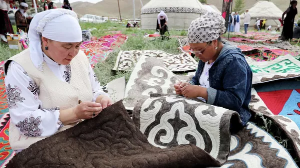 Женщины работают над созданием войлочных ковров. Архивное фото - Sputnik Кыргызстан