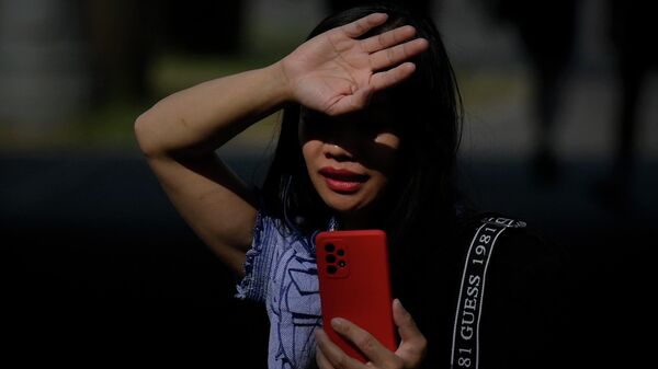 Женщина пытается закрыть лицо от солнца в жаркий летний день. Архивное фото - Sputnik Кыргызстан
