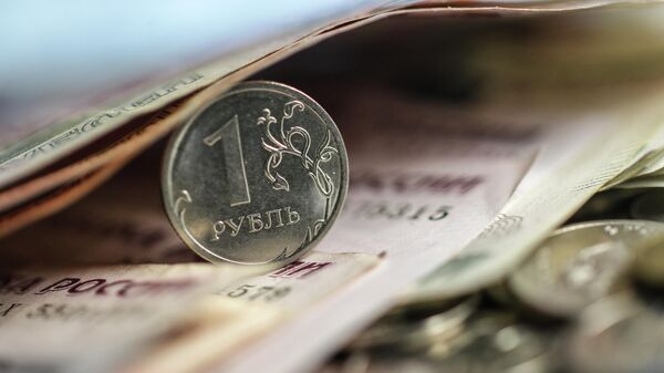 Монета номиналом в 1 рубль на фоне рублевых купюр. Архивное фото  - Sputnik Кыргызстан