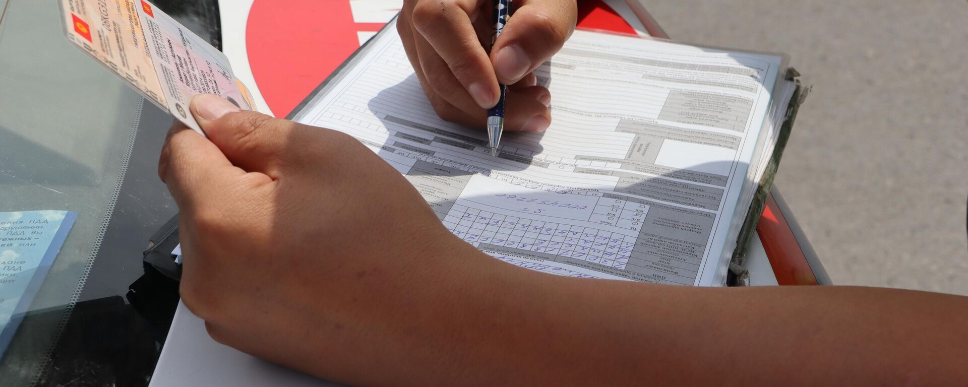 Сотрудник ГУОБДД МВД составляет протокол о нарушении. Архивное фото - Sputnik Кыргызстан, 1920, 17.03.2026