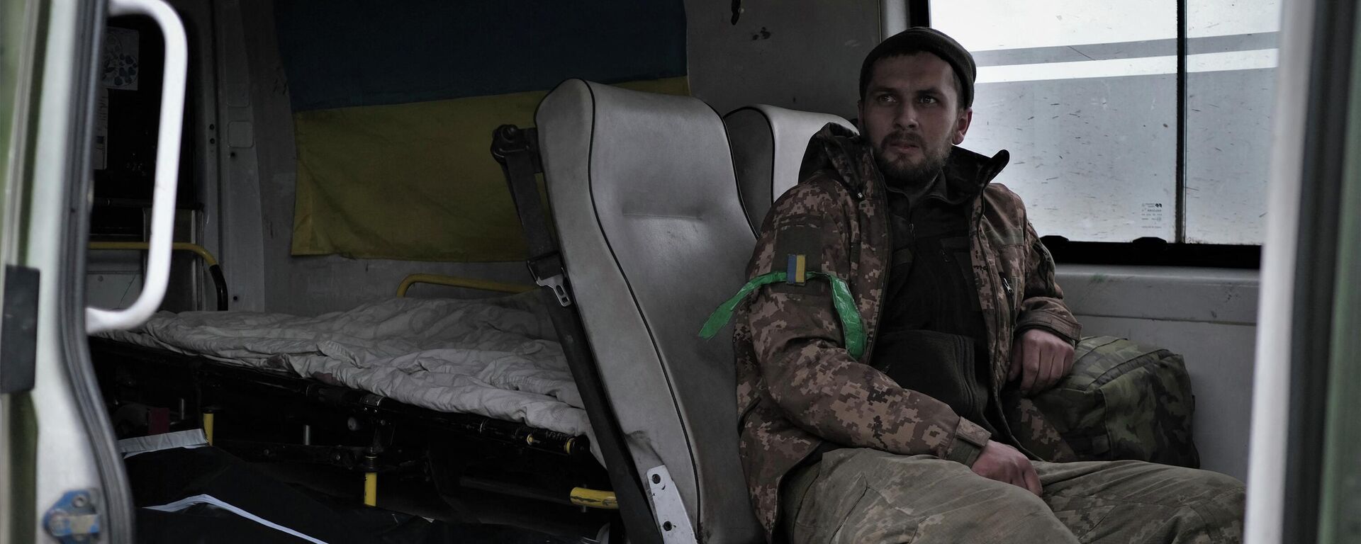 Раненый украинский солдат сидит рядом с с завернутым телом в машине медицинской эвакуации на дороге недалеко от Бахмута. Архивное фото - Sputnik Кыргызстан, 1920, 22.07.2023