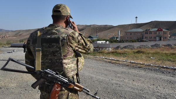 Кыргызский военнослужащий говорит по телефону перед пограничной заставой в селе Мин-Булак возле границы с Таджикистаном. Архивное фото - Sputnik Кыргызстан