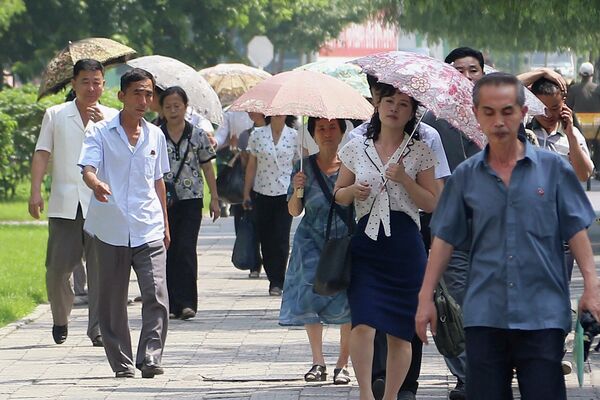 Люди закрываются зонтами от палящего солнца (Северная Корея) - Sputnik Кыргызстан