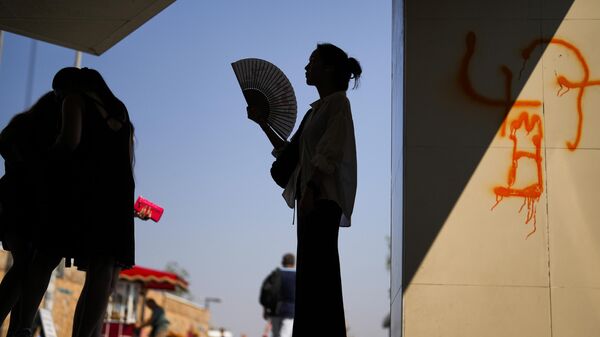 Девушка с веером спасается от жары в тени. Архивное фото - Sputnik Кыргызстан