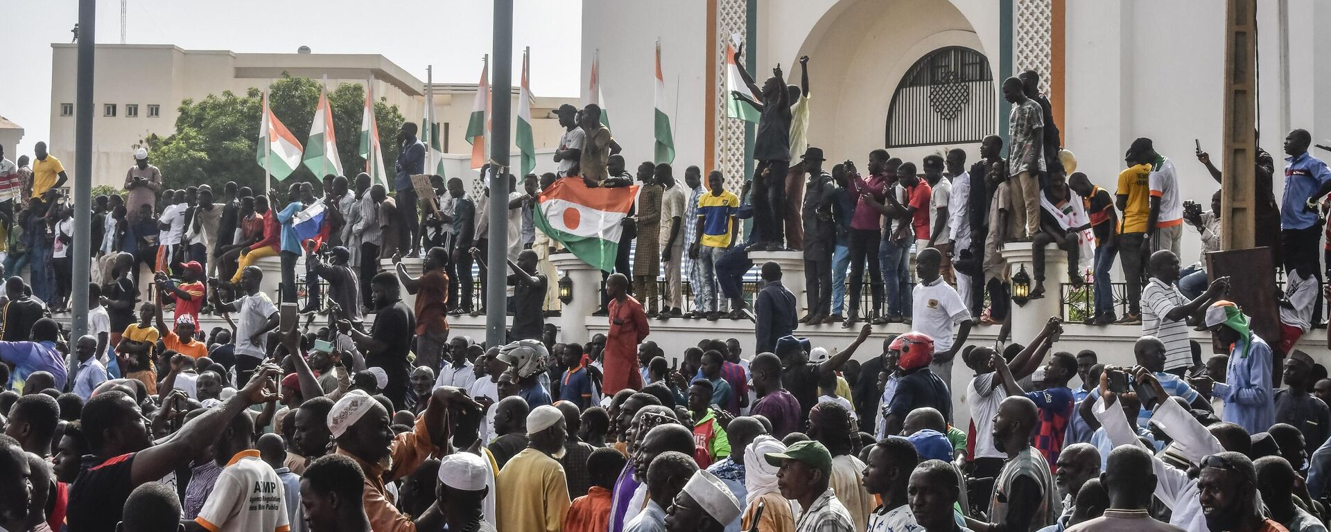 Сторонники нигерийской хунты размахивают флагами Нигерии во время митинга перед Национальным собранием в Ниамее. Нигер - Sputnik Кыргызстан, 1920, 01.08.2023