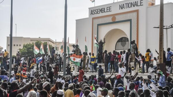 Сторонники нигерийской хунты размахивают флагами Нигерии во время митинга перед Национальным собранием в Ниамее. Нигер - Sputnik Кыргызстан