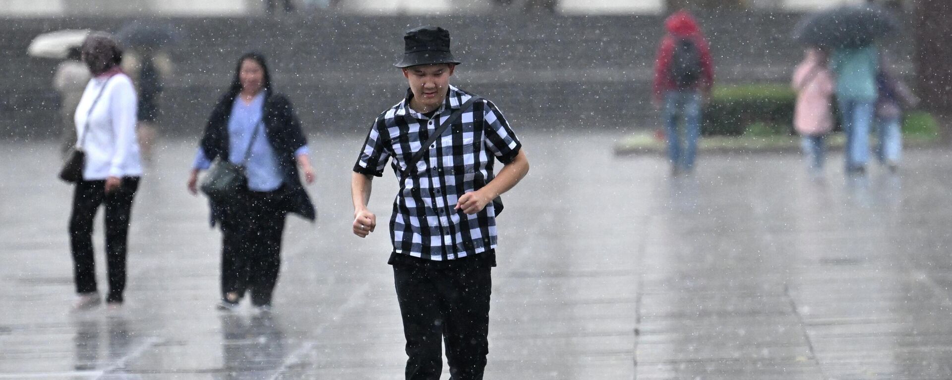 Молодой человек бежит под дождем. Архивное фото - Sputnik Кыргызстан, 1920, 06.08.2023