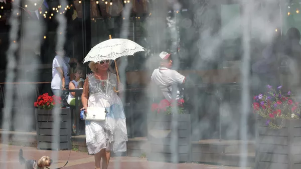 Женщина с зонтом идет по парку в жаркую погоду. Архивное фото  - Sputnik Кыргызстан