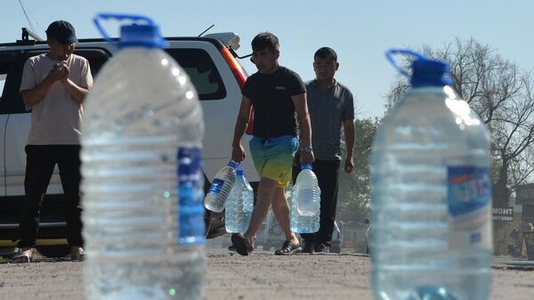 Люди с бутылями несут воду в Бишкеке. Архивное фото - Sputnik Кыргызстан