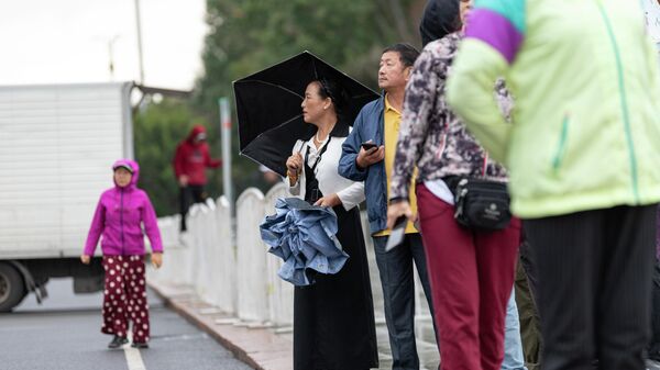 Люди с зонтами на площади Ала-Тоо во время дождя в Бишкеке. Архивное фото - Sputnik Кыргызстан