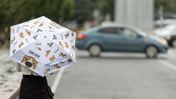 Девушка с зонтом на площади Ала-Тоо во время дождливой погоды в Бишкеке. Архивное фото - Sputnik Кыргызстан