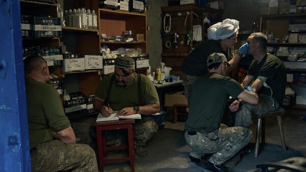 Военные медики оказывают помощь раненому украинскому солдату в полевом госпитале под Бахмутом - Sputnik Кыргызстан