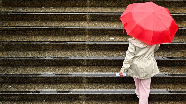 Девушка с зонтом поднимается по лестнице во время дождя. Архивное фото - Sputnik Кыргызстан