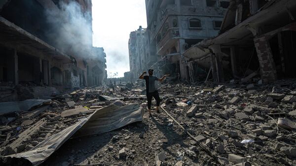 Палестинец идет среди разрушений в результате израильской бомбардировки в городе Газа - Sputnik Кыргызстан