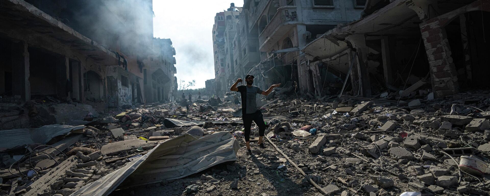 Палестинец идет среди разрушений в результате израильской бомбардировки в городе Газа - Sputnik Кыргызстан, 1920, 13.10.2023