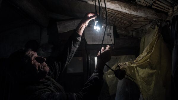 Мужчина включает лампочку в своем доме. Архивное фото - Sputnik Кыргызстан
