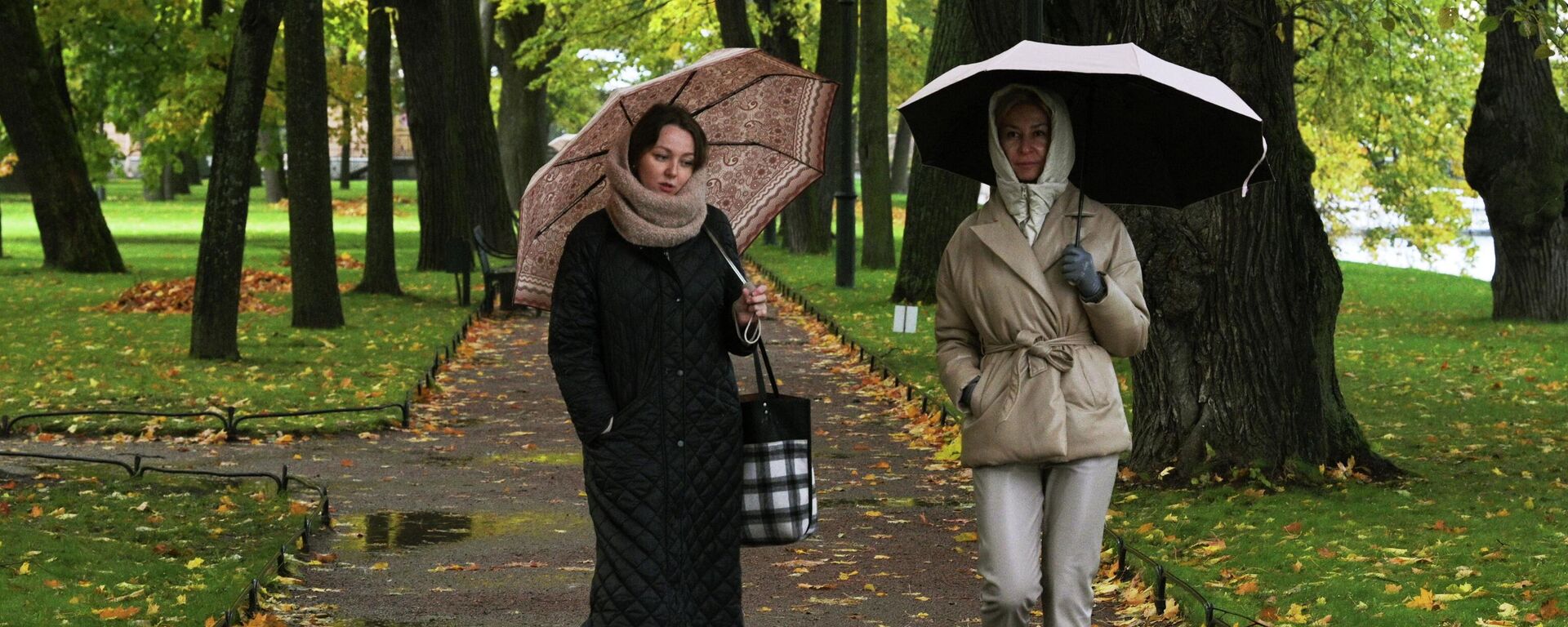 Женщины гуляют по парку в дождливую погоду - Sputnik Кыргызстан, 1920, 22.10.2023