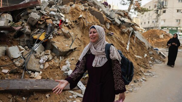 Женщина рядом с обломками здания после израильских ударов по Рафаху на юге сектора Газа, на фоне продолжающихся боев между Израилем и палестинской группировкой ХАМАС - Sputnik Кыргызстан