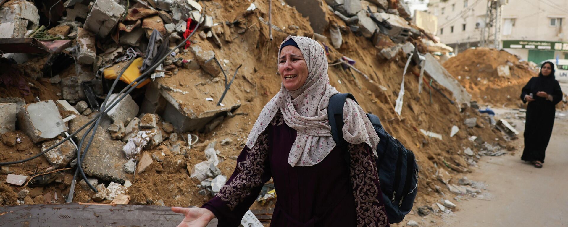 Женщина рядом с обломками здания после израильских ударов по Рафаху на юге сектора Газа, на фоне продолжающихся боев между Израилем и палестинской группировкой ХАМАС - Sputnik Кыргызстан, 1920, 26.10.2023