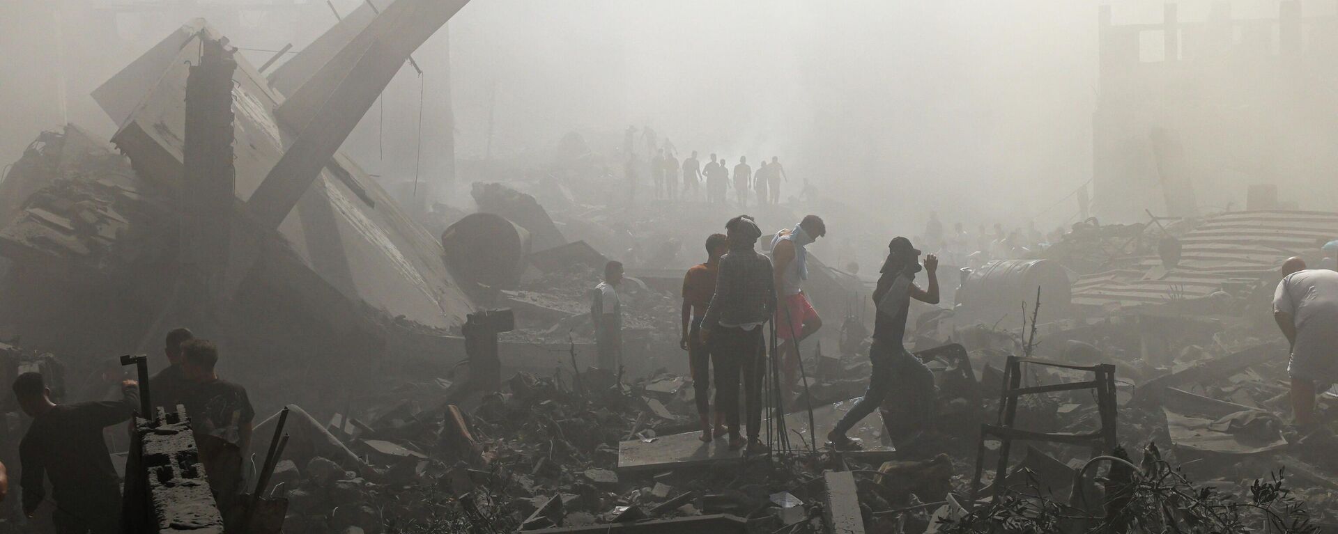 Палестинцы ищут выживших и тела жертв среди обломков зданий, разрушенных во время израильской бомбардировки на юге сектора Газа - Sputnik Кыргызстан, 1920, 27.10.2023