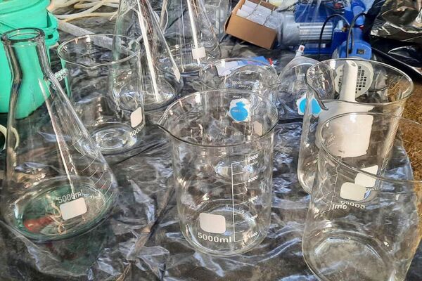 Были обнаружены полиэтиленовый пакет с мефедроном, 25 канистр, наполненных неизвестной жидкостью, а также специализированный инвентарь: аппараты, насосы, весы, ведра, колбы и другие стеклянные емкости - Sputnik Кыргызстан