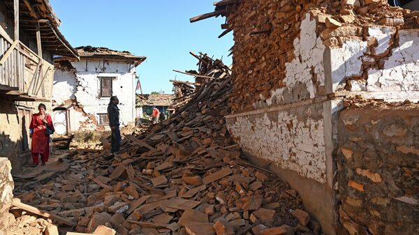 Мужчина смотрит на поврежденные дома после землетрясения в районе Джаджаркот - Sputnik Кыргызстан