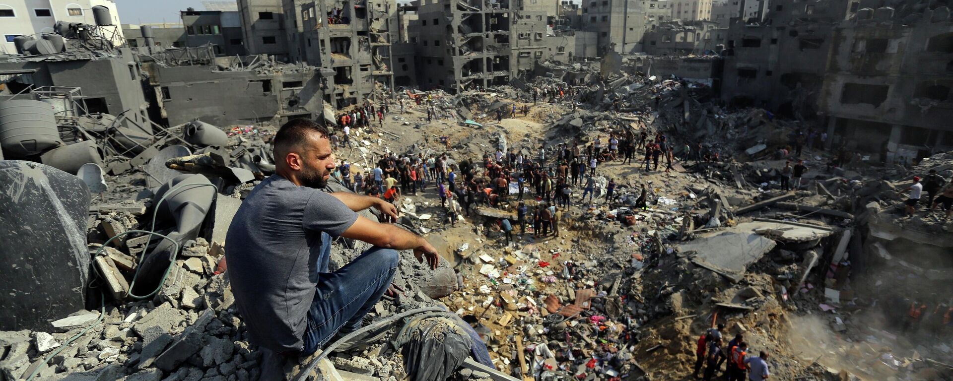 Мужчина сидит на обломках разрушенных после израильского авиаудара зданий в лагере беженцев Джабалия на севере сектора Газа - Sputnik Кыргызстан, 1920, 09.11.2023