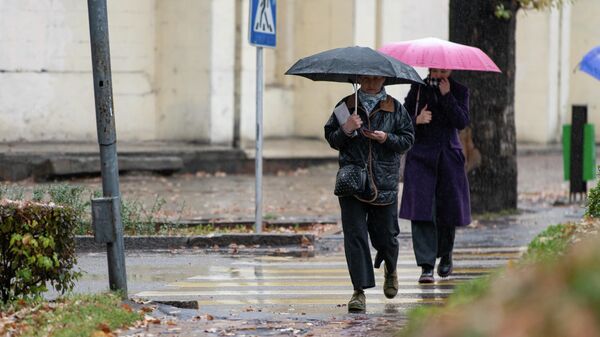 Люди с зонтами идут во время дождя в Бишкеке - Sputnik Кыргызстан