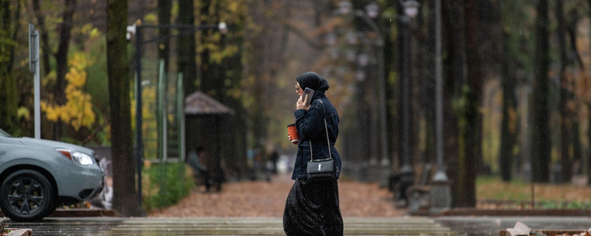 Девушка идет по бульвару Эркиндик во время дождя в Бишкеке. Архивное фото - Sputnik Кыргызстан, 1920, 30.10.2025