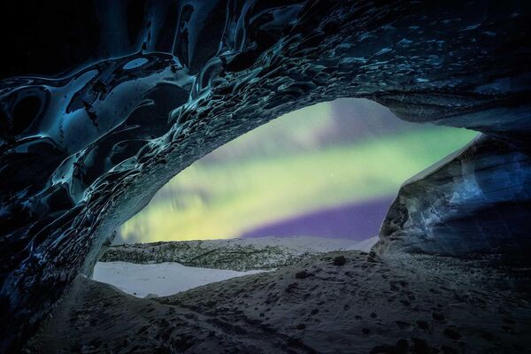 Американка Мэри Бет Киценски запечатлела северное сияние из ледяной пещеры на Аляске. Свою работу она назвала &quot;Мимолетные мгновения на льду&quot;.  - Sputnik Кыргызстан